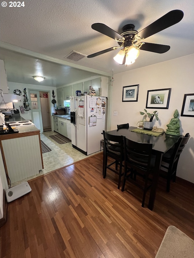 interior space with ceiling fan, light hardwood / wood-style floors, white fridge with ice dispenser, and a textured ceiling