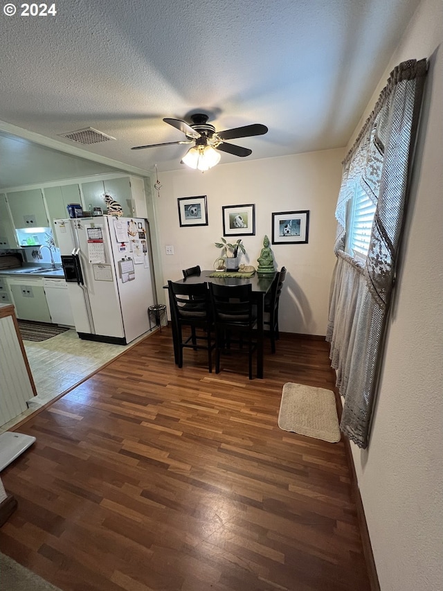 dining space featuring a textured ceiling, dark hardwood / wood-style floors, and ceiling fan