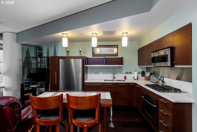 kitchen with visible vents, a sink, dark wood-style flooring, light countertops, and stainless steel appliances