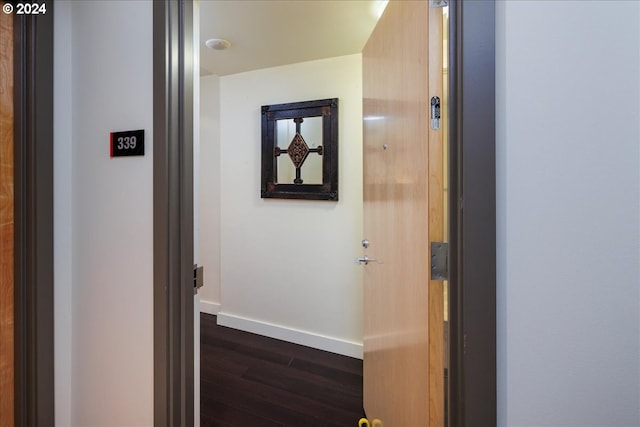 corridor with baseboards and dark wood finished floors