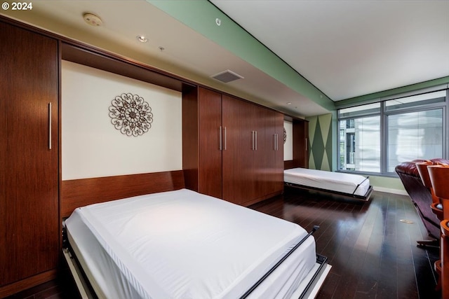 bedroom with dark wood-style floors and visible vents