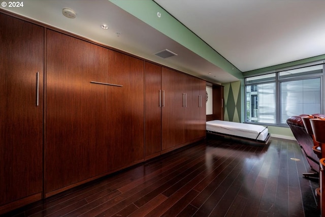 unfurnished bedroom with a closet and dark wood-type flooring