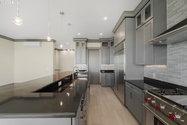 kitchen with premium appliances, decorative light fixtures, decorative backsplash, and a wall mounted air conditioner