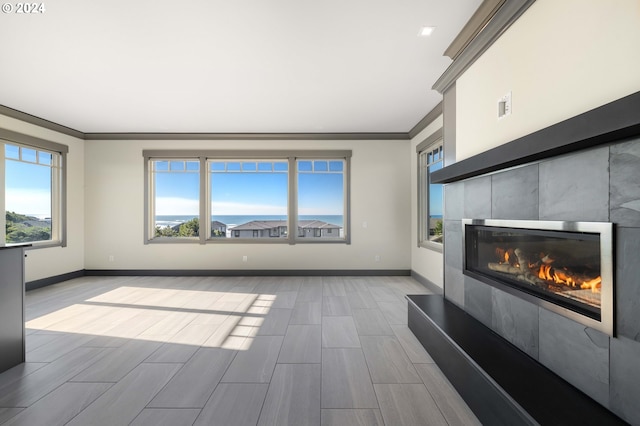 unfurnished living room with a wealth of natural light, light hardwood / wood-style flooring, and crown molding