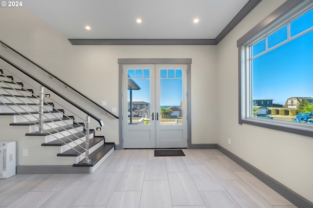 entryway with crown molding and french doors