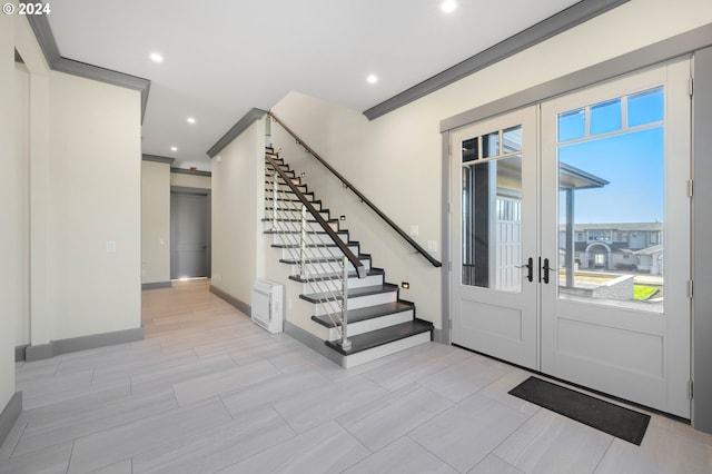 entryway featuring a wealth of natural light, french doors, and crown molding