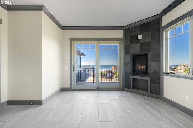 unfurnished living room featuring a large fireplace and crown molding