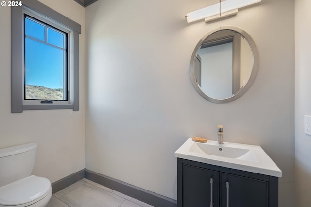 bathroom with tile patterned flooring, vanity, and toilet