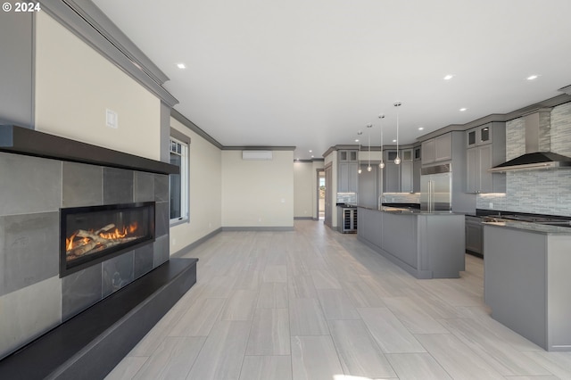 kitchen featuring built in fridge, decorative light fixtures, a center island, and gray cabinetry