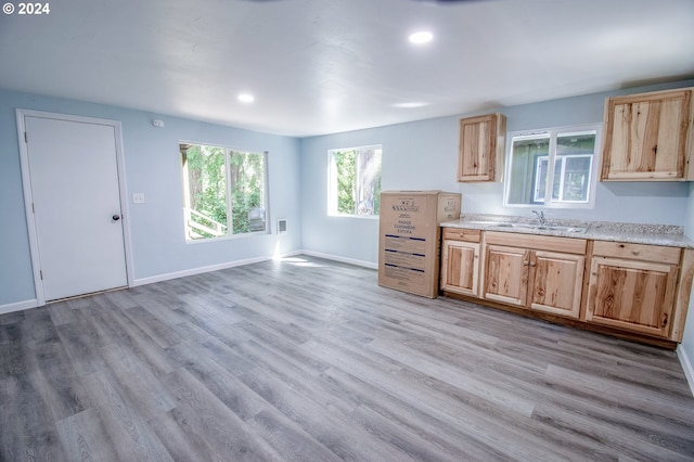 kitchen featuring light brown cabinetry, sink, and light hardwood / wood-style flooring