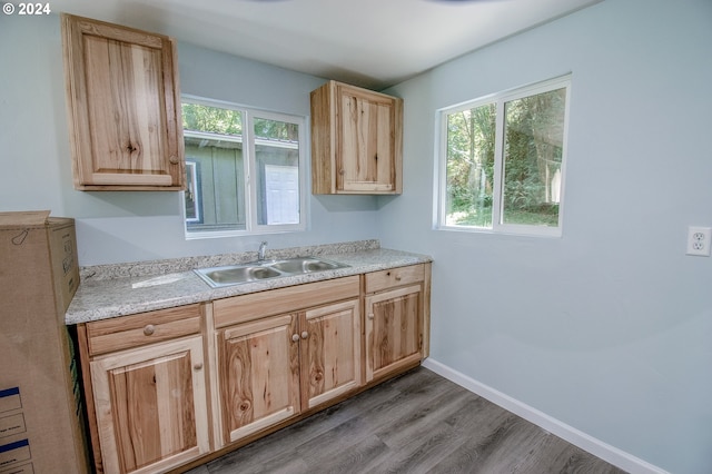 kitchen with light brown cabinetry, sink, and light wood-type flooring