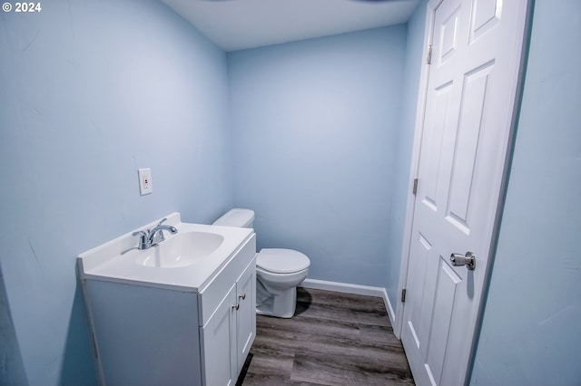 bathroom with wood-type flooring, toilet, and vanity