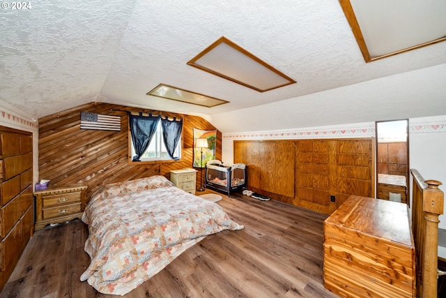 bedroom with a textured ceiling and dark hardwood / wood-style floors