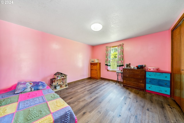 bedroom featuring a closet, a textured ceiling, and hardwood / wood-style flooring