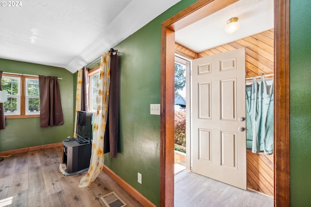 foyer featuring light hardwood / wood-style flooring and wooden walls