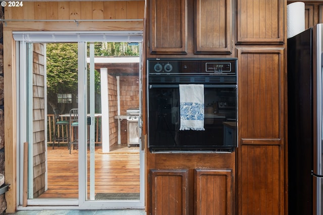 kitchen with light hardwood / wood-style flooring, stainless steel refrigerator, and oven