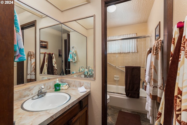 full bathroom featuring shower / bath combination with glass door, tile floors, a textured ceiling, toilet, and vanity