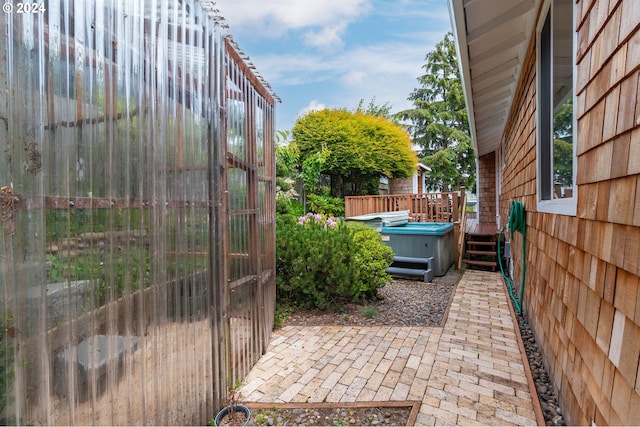 view of terrace with a deck and a hot tub