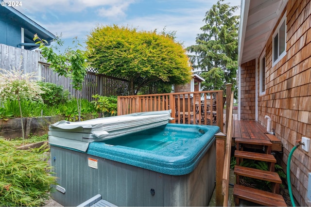 view of swimming pool featuring a deck and a hot tub