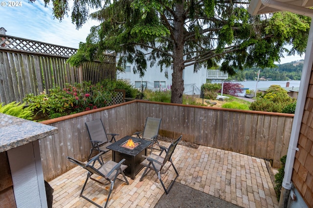 view of patio featuring a fire pit and a water view