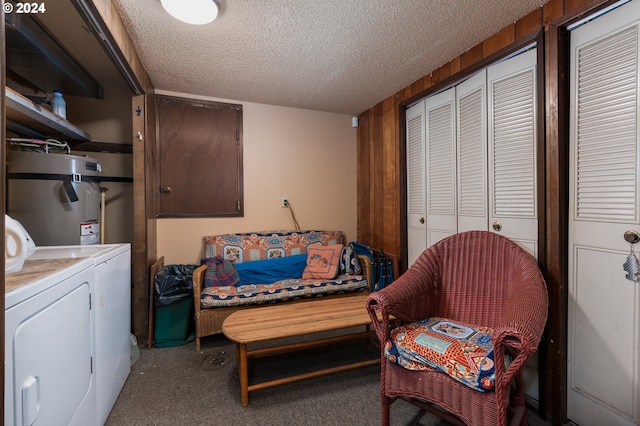 interior space with a textured ceiling, water heater, carpet floors, and independent washer and dryer