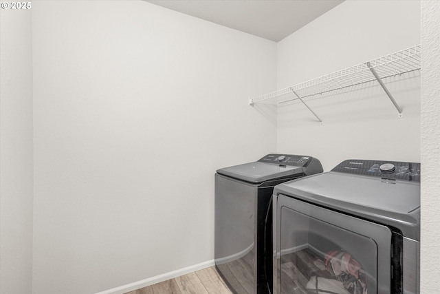 washroom with washing machine and dryer and wood-type flooring