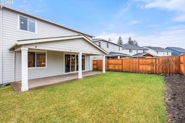 rear view of property featuring a lawn and a patio area