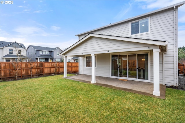 rear view of property featuring a lawn and a patio