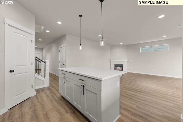 1353 NE Josephine Ct Unit 167, Estacada, OR 97023 - kitchen featuring light wood finished floors, a glass covered fireplace, and baseboards