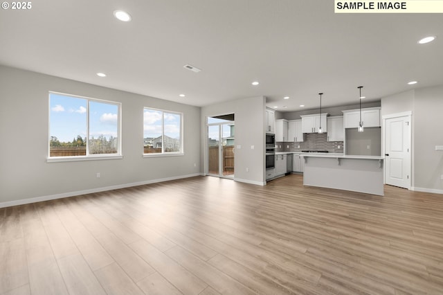 1353 NE Josephine Ct Unit 167, Estacada, OR 97023 - unfurnished living room featuring recessed lighting, light wood finished floors, visible vents, and baseboards