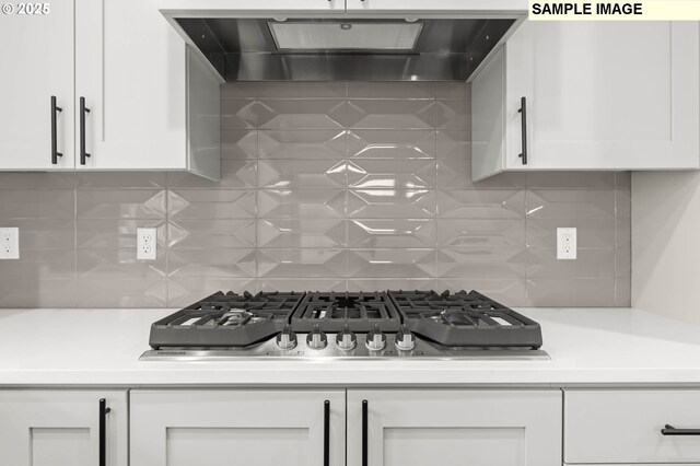 1353 NE Josephine Ct Unit 167, Estacada, OR 97023 - kitchen featuring stainless steel gas stovetop, wall chimney exhaust hood, backsplash, white cabinetry, and light countertops
