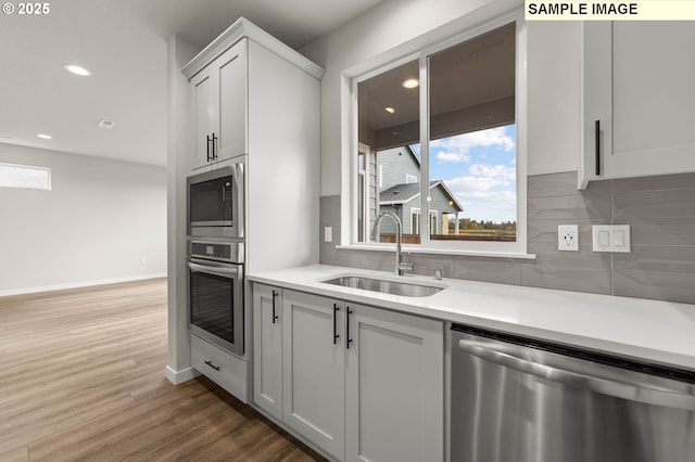 1353 NE Josephine Ct Unit 167, Estacada, OR 97023 - kitchen featuring decorative backsplash, stainless steel appliances, light countertops, a sink, and dark wood-style floors