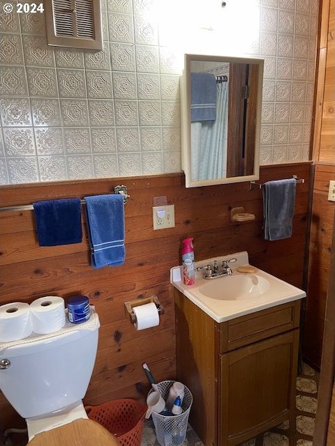 bathroom featuring vanity and wood walls