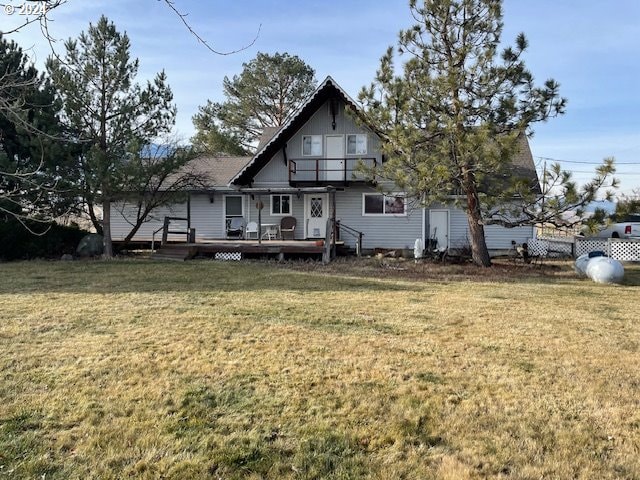 rear view of property featuring a lawn and a wooden deck