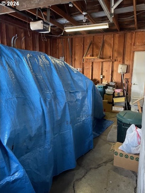 interior space with a garage door opener and wood walls