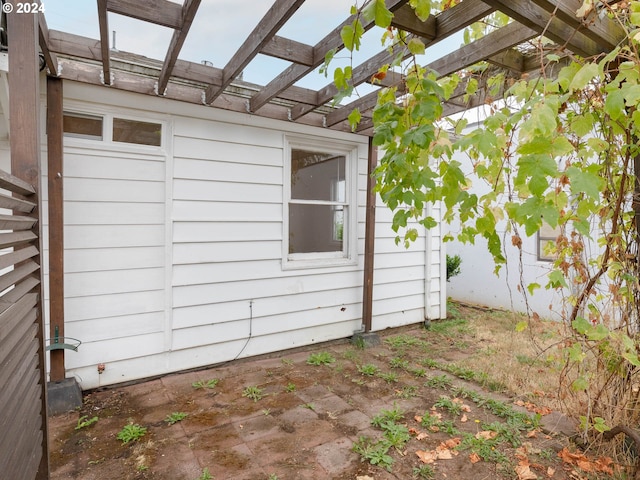 view of side of property featuring a patio area and a pergola