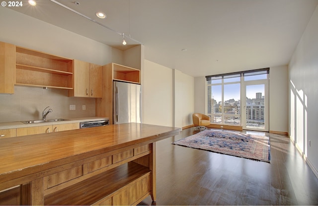 kitchen with wood counters, backsplash, stainless steel appliances, sink, and hardwood / wood-style floors