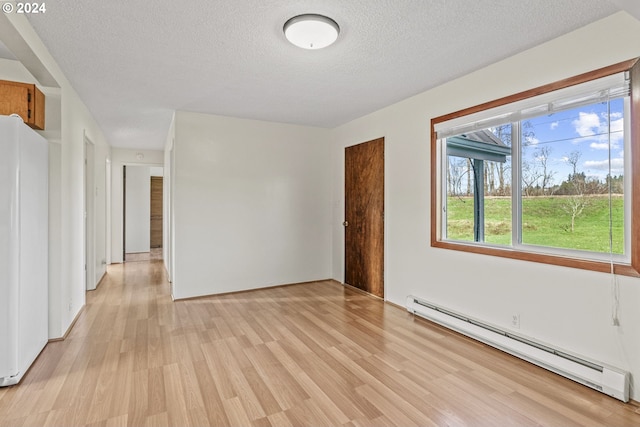 252 State Route 409, Cathlamet, WA 98612 - empty room with light hardwood / wood-style floors, a textured ceiling, and a baseboard radiator