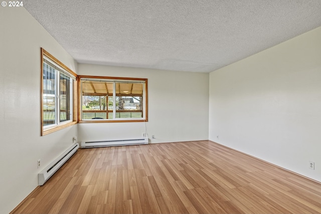 252 State Route 409, Cathlamet, WA 98612 - spare room featuring baseboard heating, light hardwood / wood-style floors, and a textured ceiling