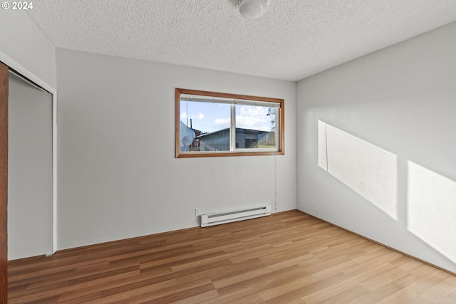 252 State Route 409, Cathlamet, WA 98612 - empty room with light wood-type flooring, a baseboard radiator, and a textured ceiling