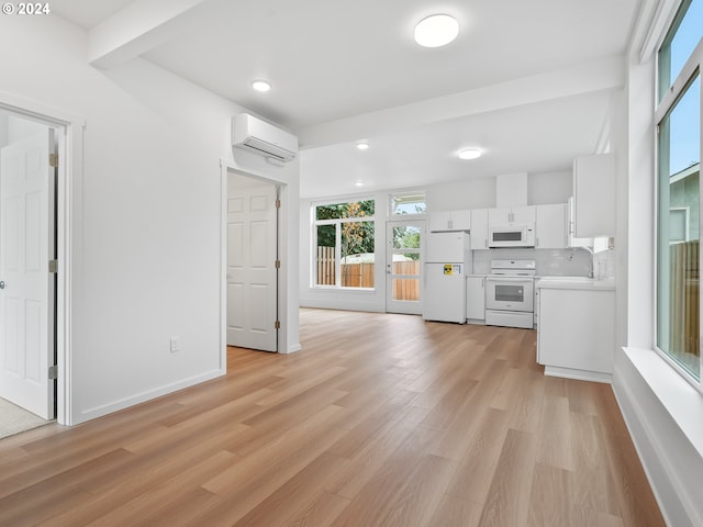 unfurnished living room with light hardwood / wood-style flooring and a wall mounted air conditioner