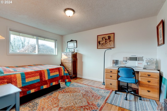 bedroom featuring a textured ceiling and light wood-type flooring