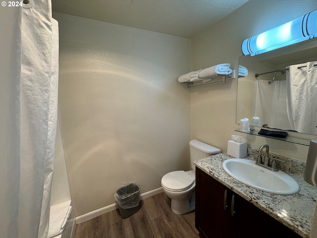 bathroom featuring a shower with curtain, hardwood / wood-style floors, toilet, and vanity