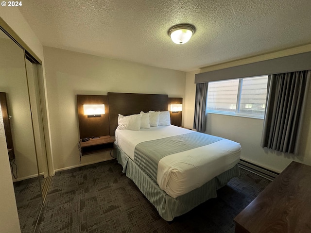 carpeted bedroom featuring baseboard heating, a textured ceiling, and a closet