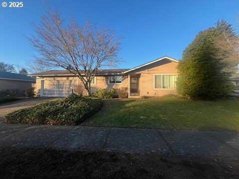 single story home featuring a garage and a front yard