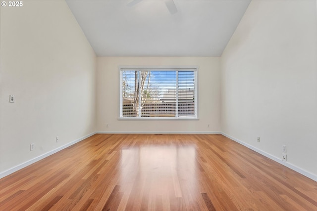 empty room with baseboards, lofted ceiling, ceiling fan, and light wood finished floors