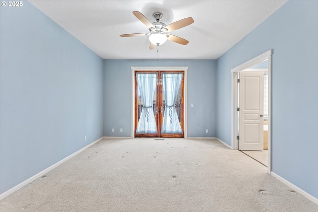 carpeted empty room featuring baseboards and ceiling fan