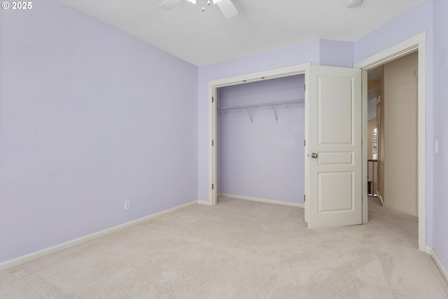 unfurnished bedroom with baseboards, carpet floors, a closet, and ceiling fan