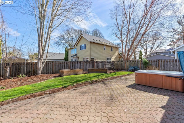 view of patio / terrace with a garden, a fenced backyard, and a hot tub