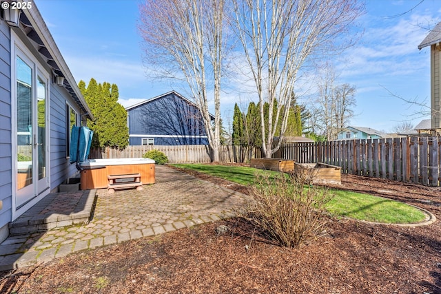 view of yard featuring a patio area, a fenced backyard, and a hot tub